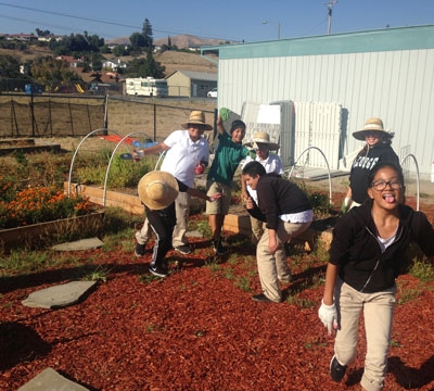 Students laughing and working in school garden